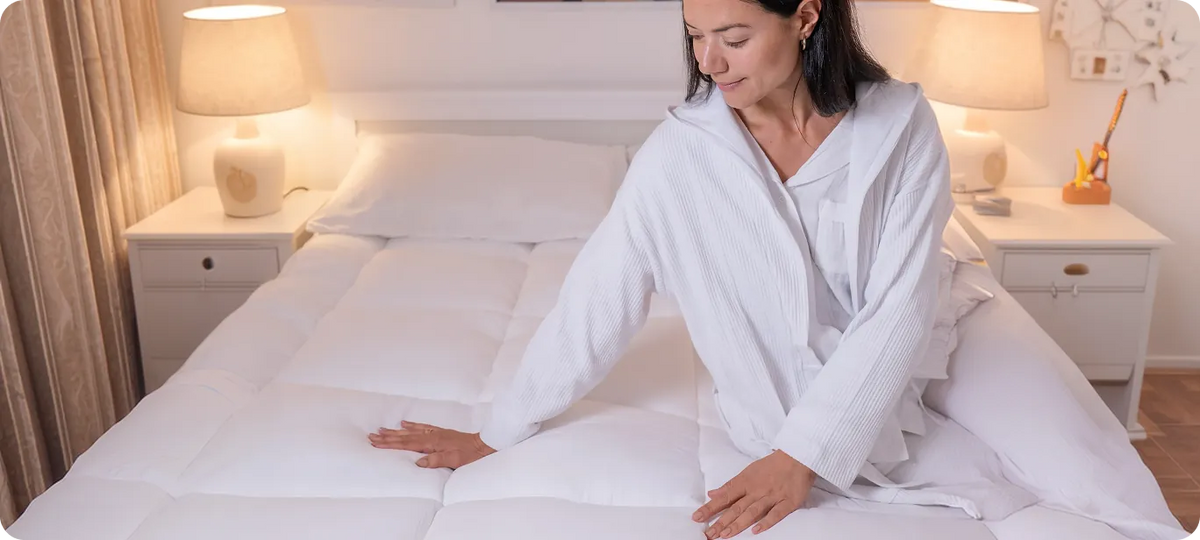 Woman sitting on a bed fitted with CloudTopper