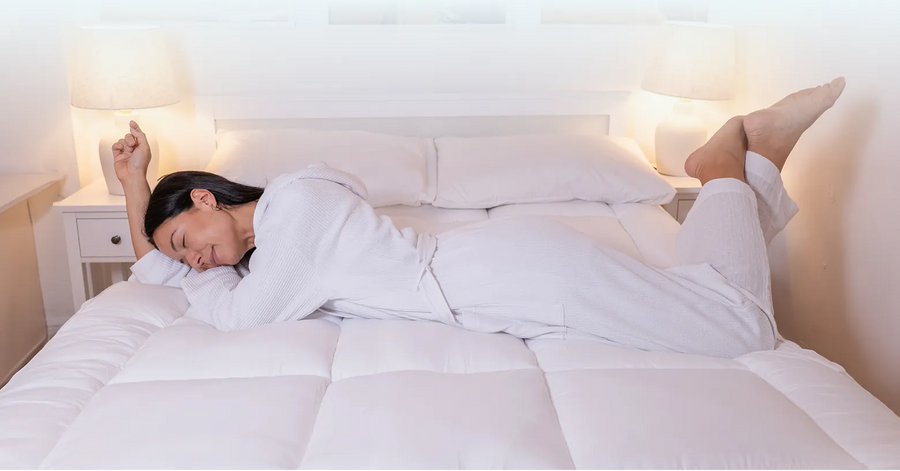 Woman stretching awake on a CloudTopper-covered bed