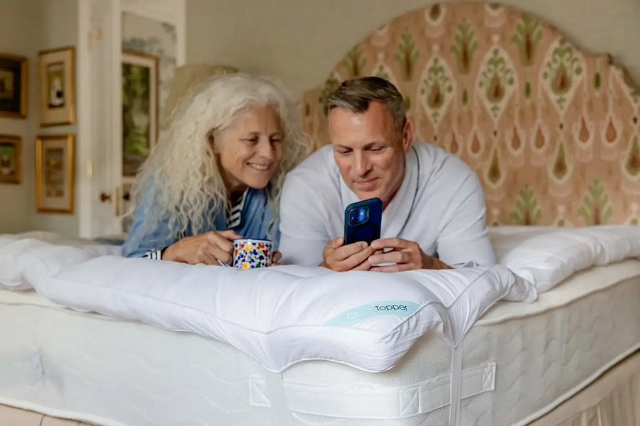 Couple relaxing on a bed fitted with CloudTopper