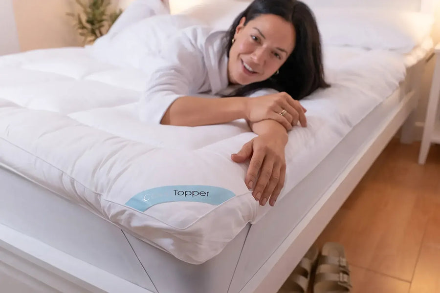 Woman relaxing on a bed fitted with CloudTopper