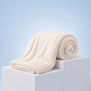 Cream luxury blanket rolled and draped on white display blocks